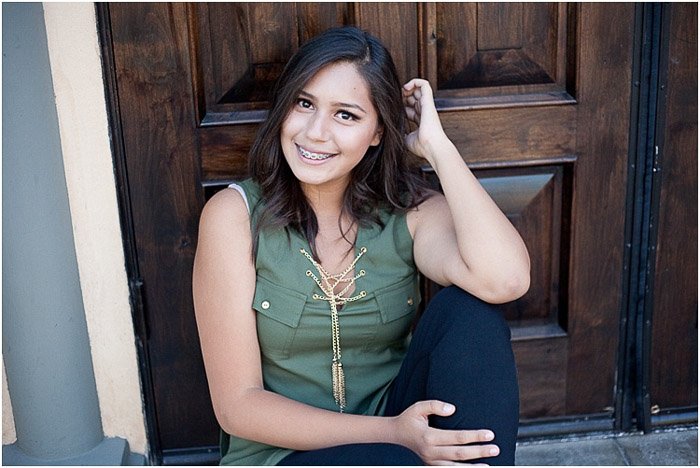 A relaxed and natural senior photography portrait of a girl posing on a step