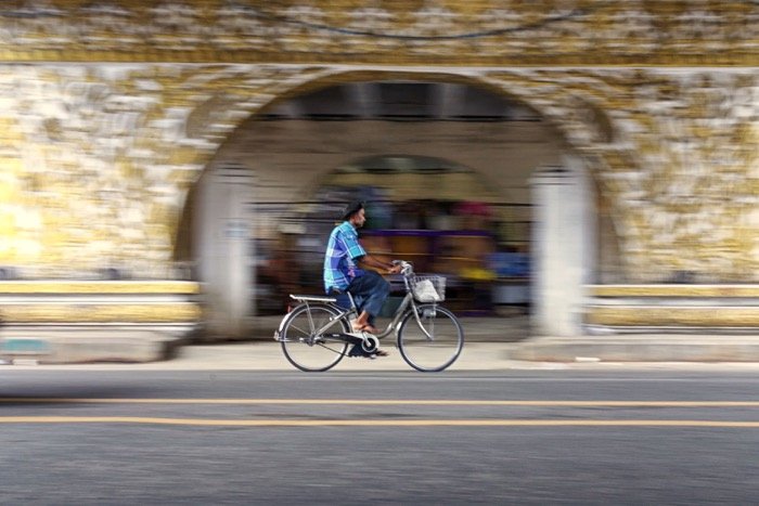 A man riding a bicycle through a tunnel