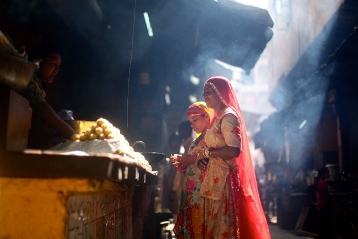 Women buying food in a market - street photography camera settings