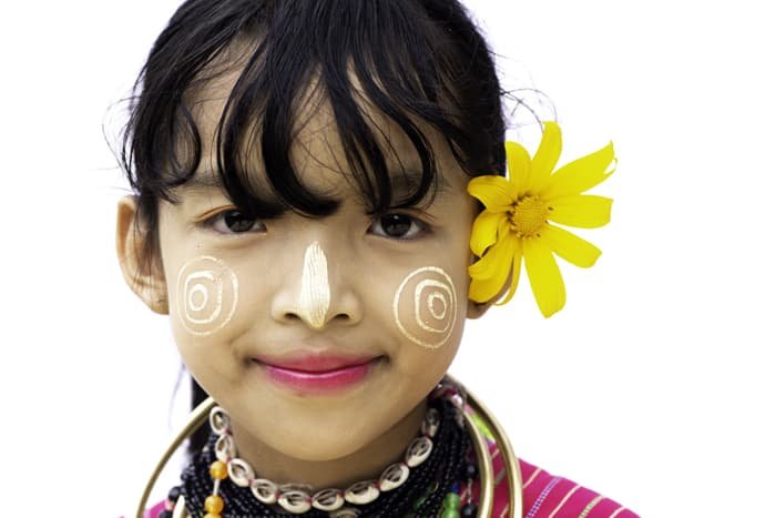 Close up portrait of a young girl in traditional face paint against a white portrait photo background