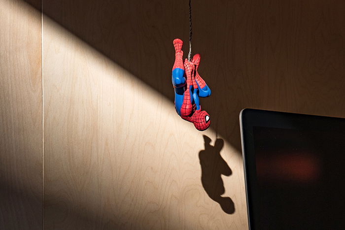 Spiderman action figure photography hanging from a rope