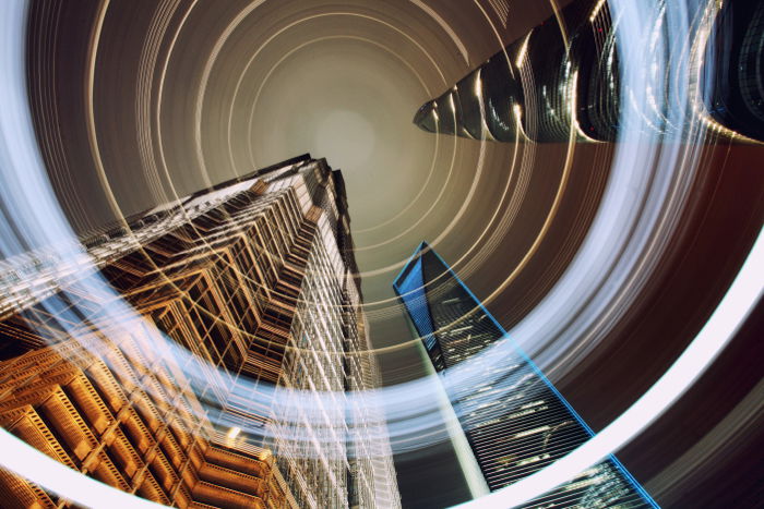 A dramatic architecture photography of facades of tall skyscrapers and cityscape shot at night 