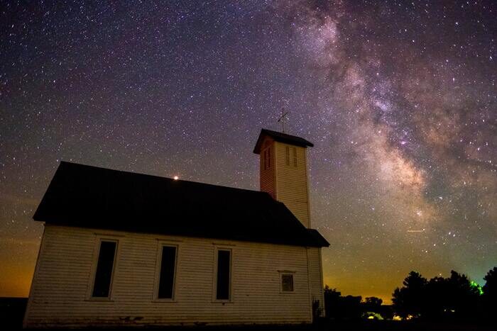 A church with the Milky Way in the night sky about it as an example of astrophotography