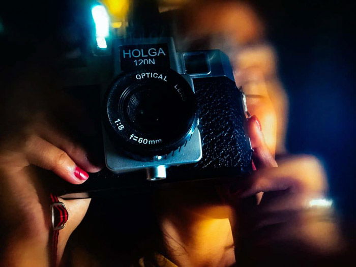 A person shooting with a holga camera, photo processed with a creative blur app