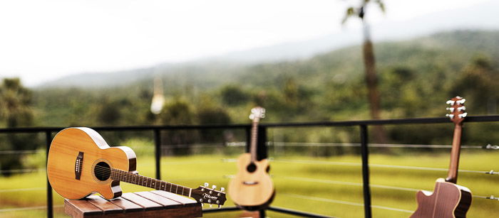 A guitar resting on an outdoor table shot with wide angle lens