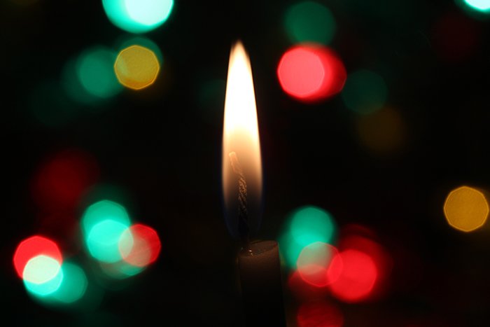 Beautiful Christmas bokeh lights in the background of a candle