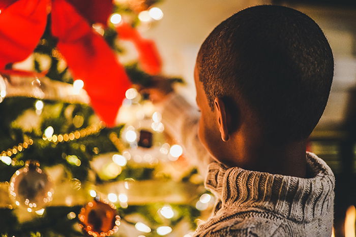 A kid decorating a Christmas tree