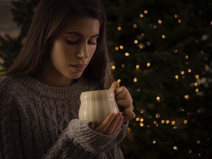A female portrait in front of a Christmas tree with bokeh lights background