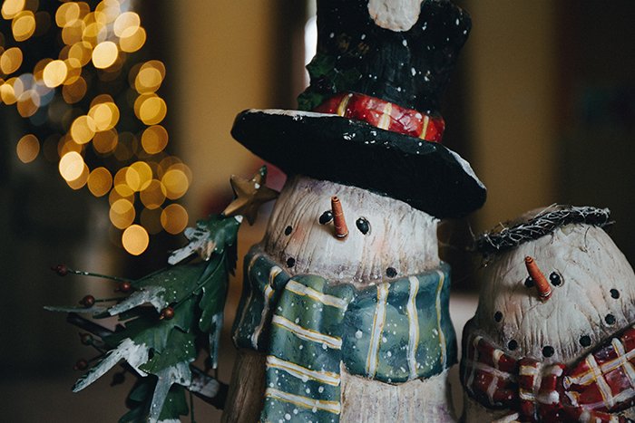 A pair of snowman ornaments with bokeh lights background