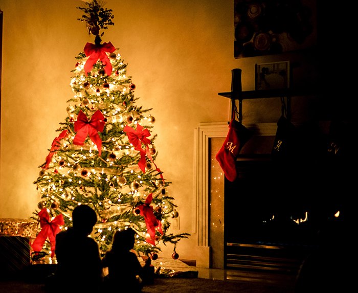 Silhouettes of children in front of the Christmas tree