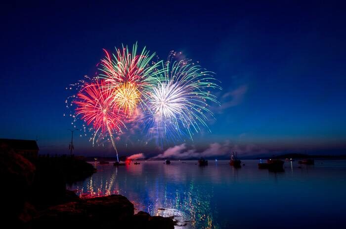 Photo of colorful fireworks above a river