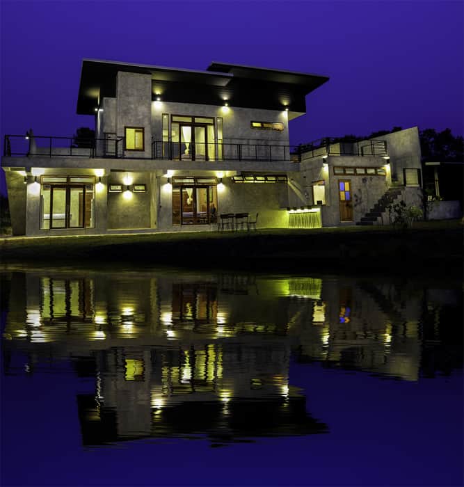 Stricking architectural shot of a house at dusk with a cool Photoshop reflection in the water below