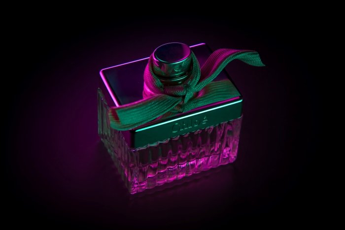Perfume bottle lit with pink neon light