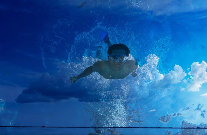 A man swimming superimposed with a photo of clouds - how to use superimpose 