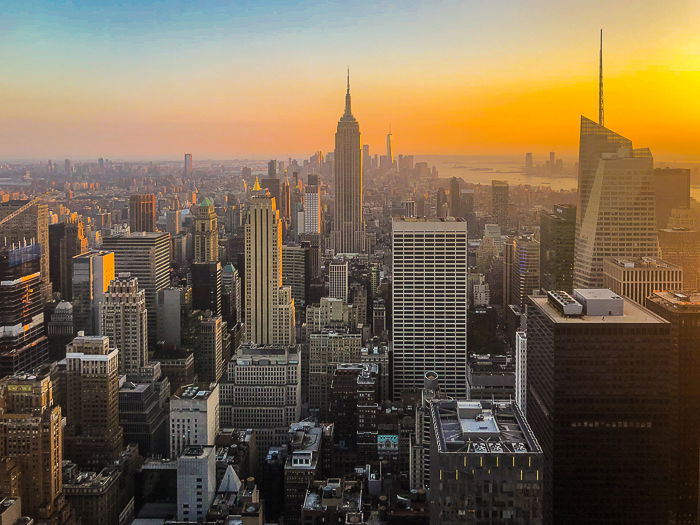 An aerial view of a sprawling cityscape under dramatic skies at sunset