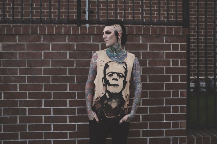 Ein tätowiertes männliches Model, das im Freien posiert - Tattoo-Fotografie