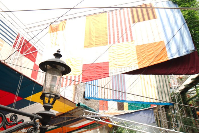 Flags and textiles hanging above a street