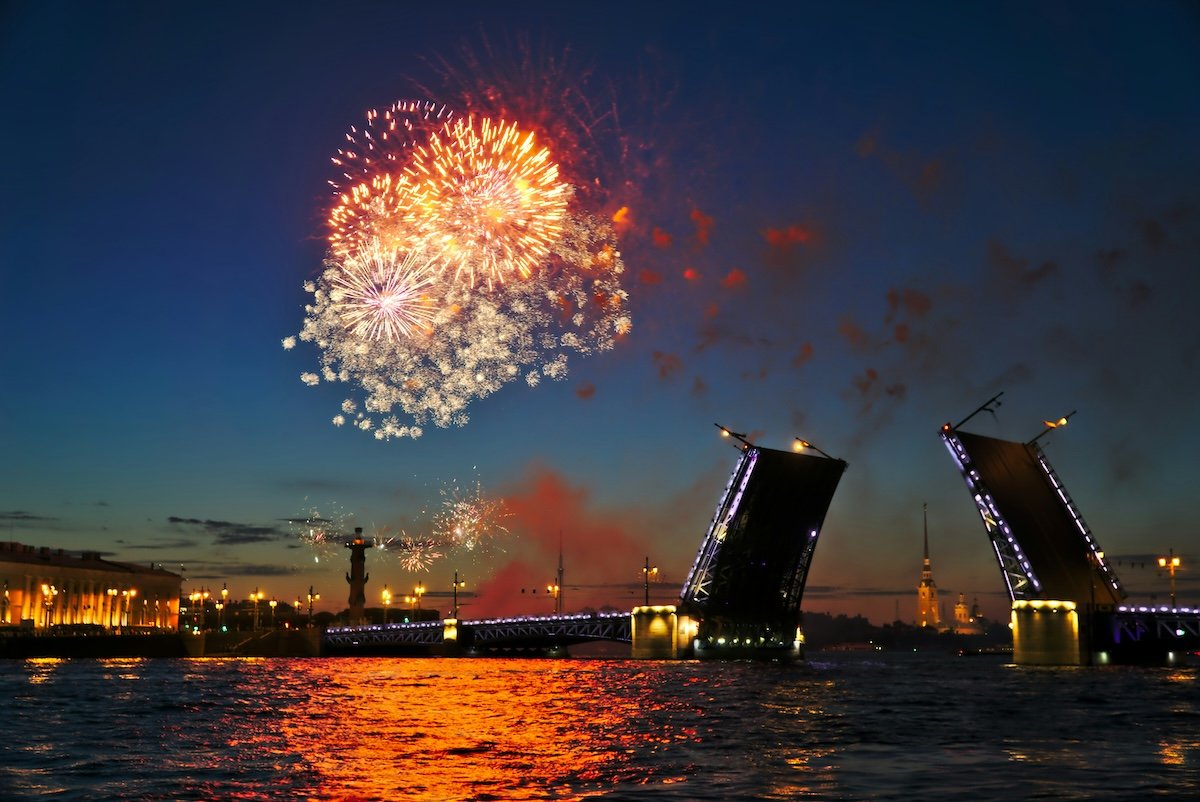 Colorful fireworks over a bridge and water showing balance in photography