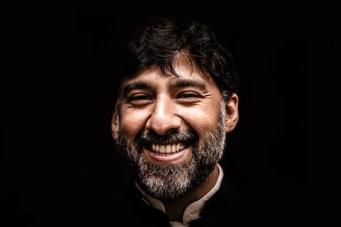 Atmospheric portrait of a smiling male model against black background 