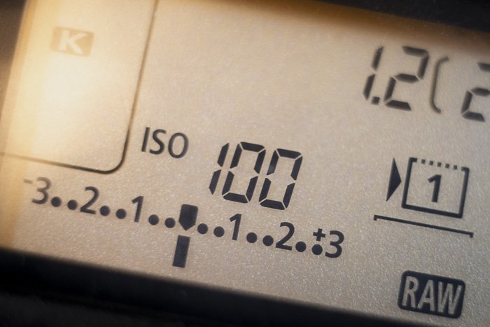 The top LCD screen on a Canon DSLR camera, with an exposure compensation scale