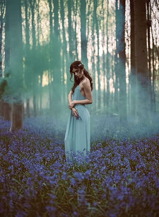 A stunning film photography style portrait of a female model posing in a dreamy forest