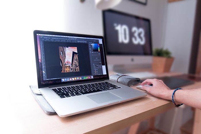A person editing photos on Lightroom 6 in a home office