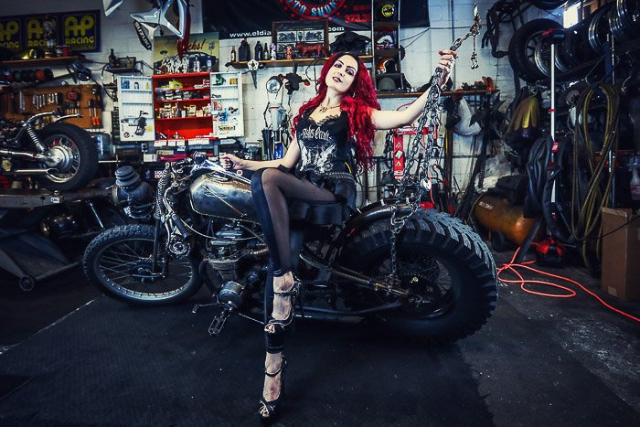 Cool motorcycle photography portrait of a female model posing on a bike