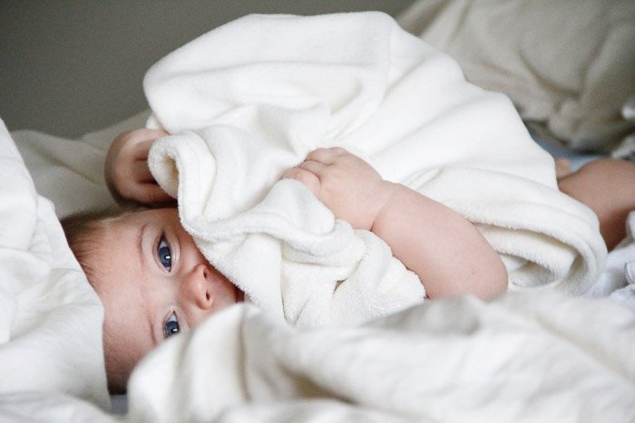 A newborn baby posed in white blanket