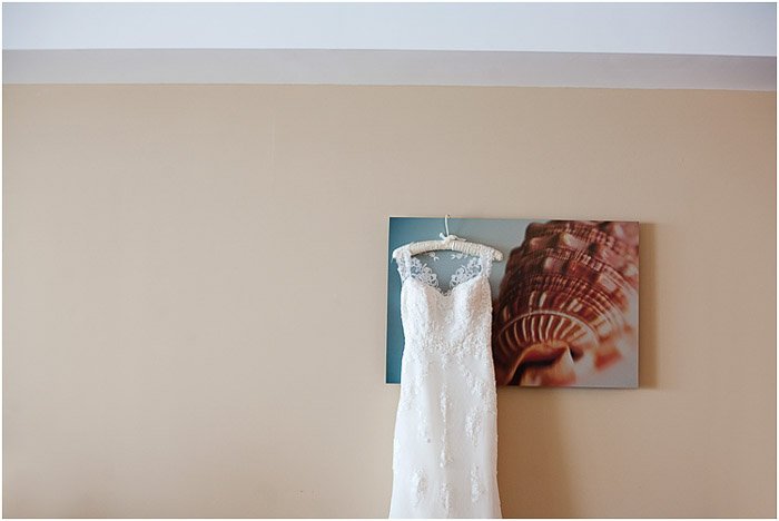 A wedding dress hanging from a mounted photo print - destination wedding tips