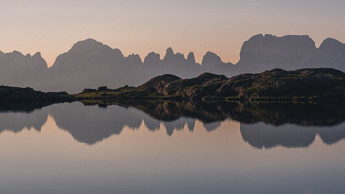 A stunning mountainous landscape over Dolomiti di Brenta relected in the lake below - reflections in photography