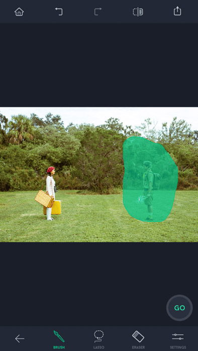 Screenshot of the touch retouch app with two people standing on the field, one of them highlighted by brush selection