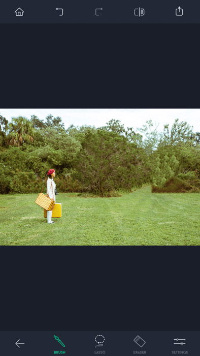 Screenshot of the touch retouch app, a woman with red hat and yellow bags standing on the field