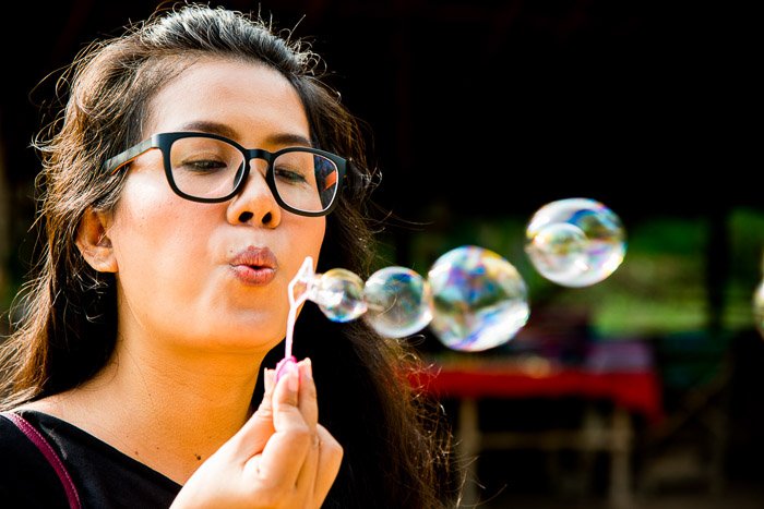 A portrait of a female model shot blowing bubbles