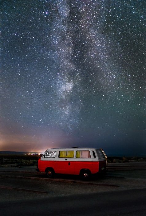 A van parked right in front of the Milky Way.