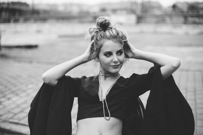 A black and white portrait of a female model posing outdoors