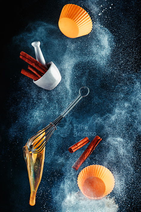 A still life shot using flying kitchen utensils and flour clouds - creative still life photography