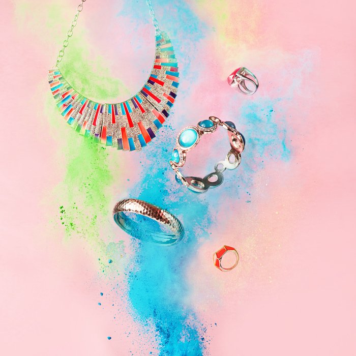 A magical still life shot using jewellery and colored flour clouds 