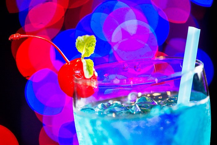 A blue cocktail with blurry bokeh light background 