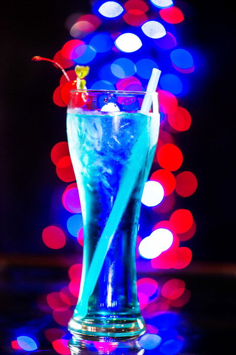 A blue cocktail with blurry bokeh light background 