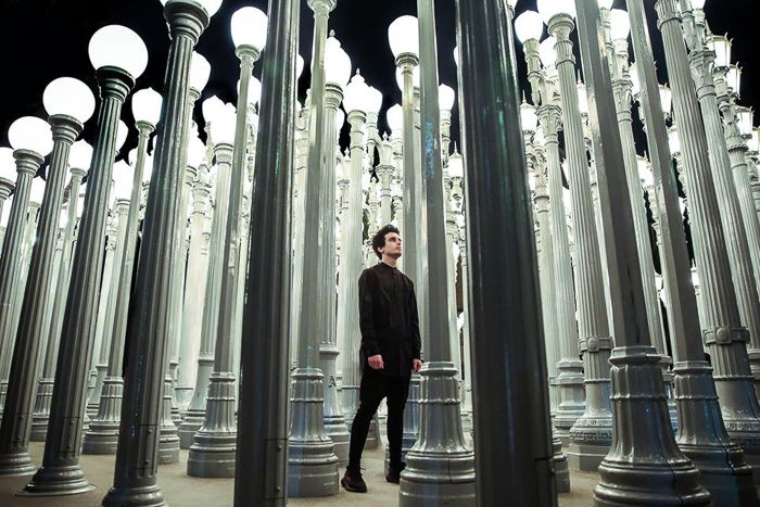 A male model posing among many street lights for an atmospheric night portrait photography shot