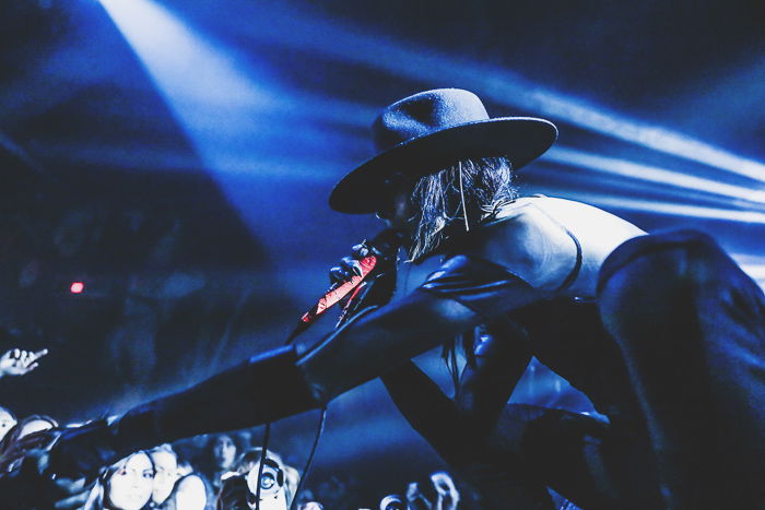 Atmospheric nightclub photography portrait of a female performer onstage in low light