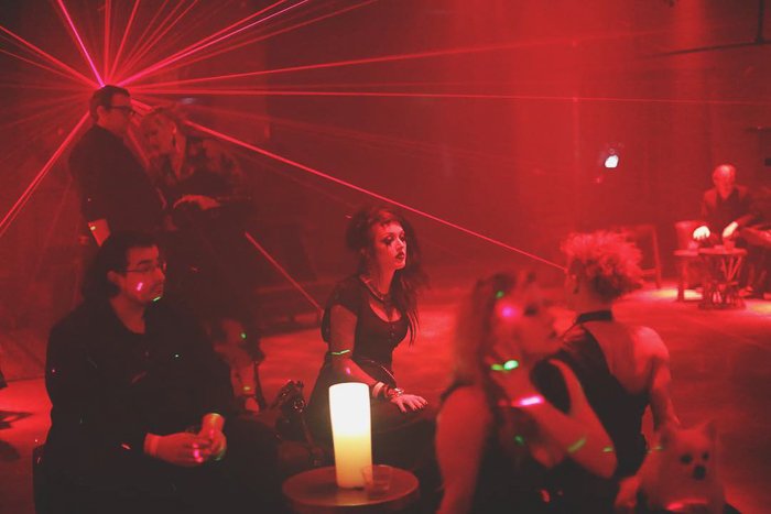 Atmospheric nightclub portrait of party goers sitting and chatting