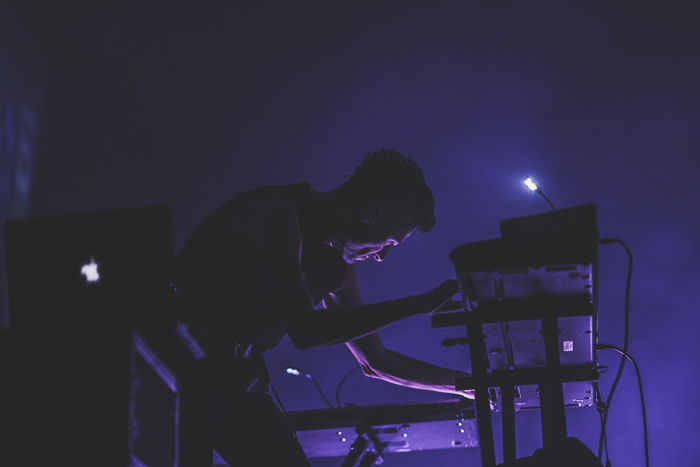 Atmospheric nightclub photography portrait of a male performer in low light