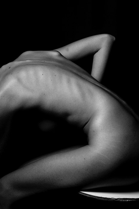 A black and white abstract body photography shot using lines to create balance and divide space