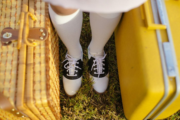 A close up of a girls feet, with suitcases on either side