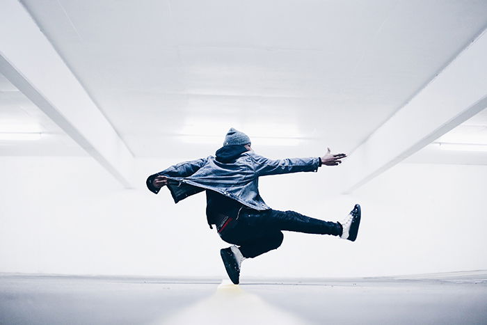 A dance photography shot of a male dancer mid jump