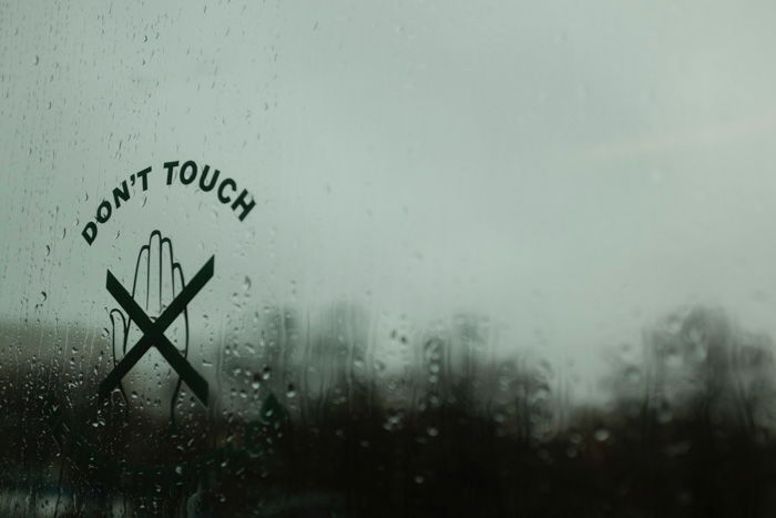 A 'don't touch' sign on a rainy window - photobooth props