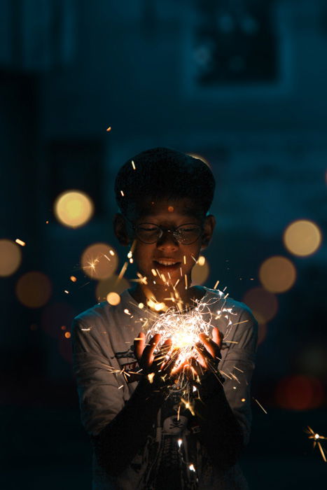 A portrait of a young boy holding a string of flickering lights shot using a DIY photo booth 