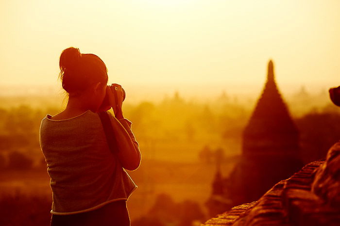 A female photographer shooting a cityscape in evening light