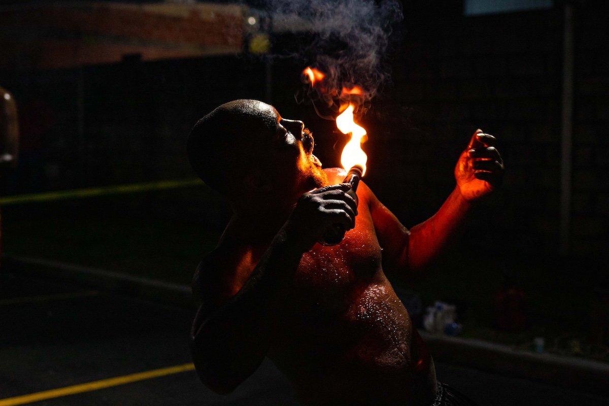 Street performer holding fire to their mouth for a fire photography portrait